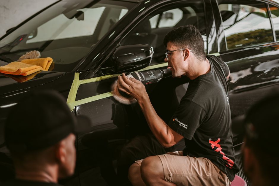 Professional auto detailer meticulously working on a vehicle's finish